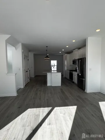 a living room with stainless steel appliances kitchen island furniture and wooden floor