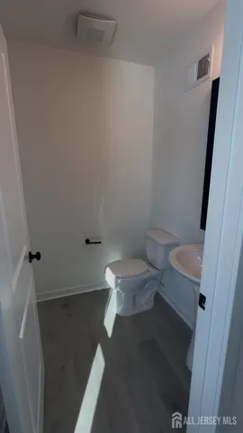 a white toilet sitting next to a white sink and vanity