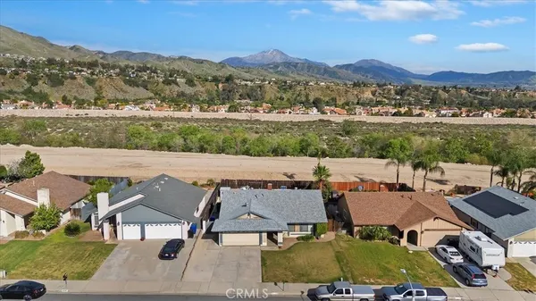 an aerial view of a house with pool and mountain view in back