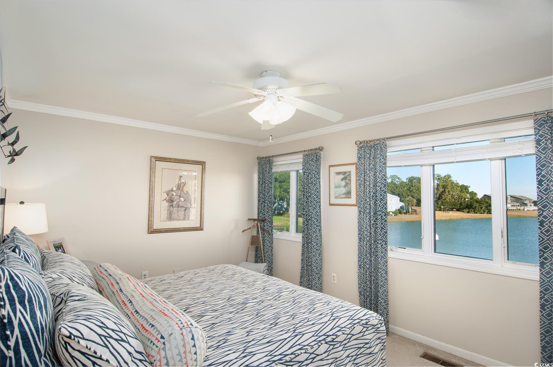 27 Pheasant Loop, Unit 293 Georgetown, SC 29440 - Photo 19 of 23 Carpeted bedroom featuring a water view, crown molding, and a ceiling fan
