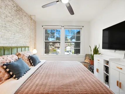 a bed room with a bed a television and a window