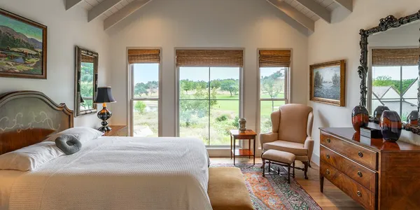 a bedroom with furniture and a large window