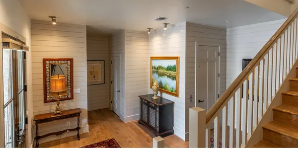 a view of a hallway with wooden floor and staircase
