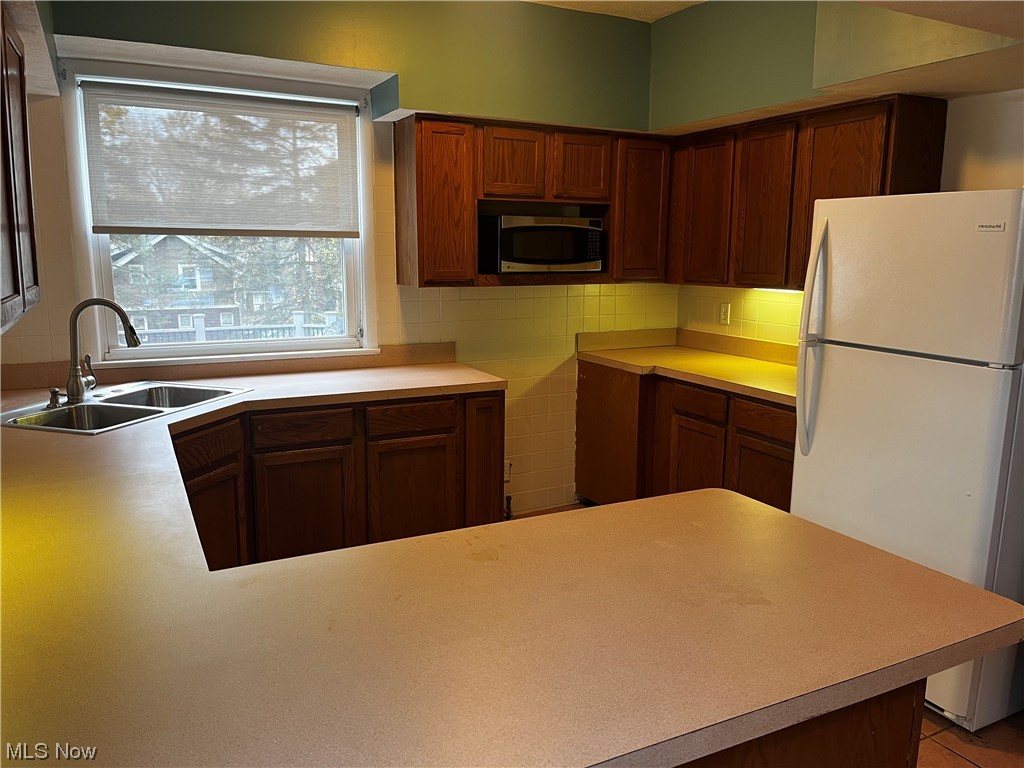1610 Malasia Road Akron, OH 44305 - Photo 6 of 14 Kitchen with tasteful backsplash, sink, plenty of natural light, and white fridge