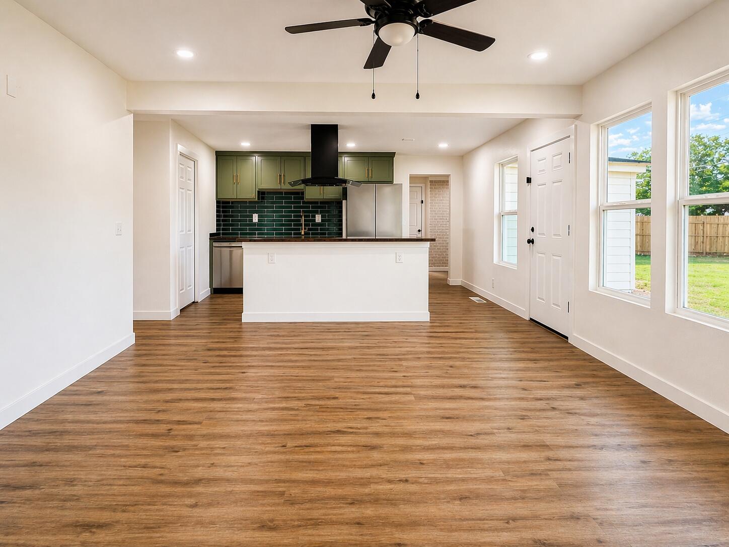 2316 48th Street Lubbock, TX 79412 - Photo 2 of 18 a view of a living room with kitchen island stainless steel appliances wooden floor and window