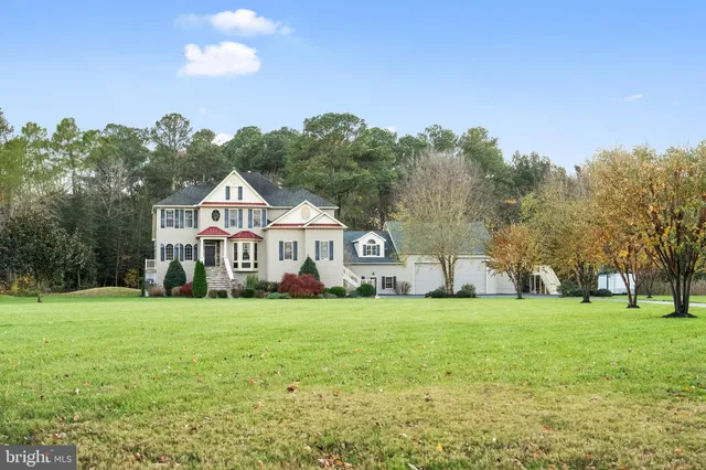 a front view of a house with a yard and trees