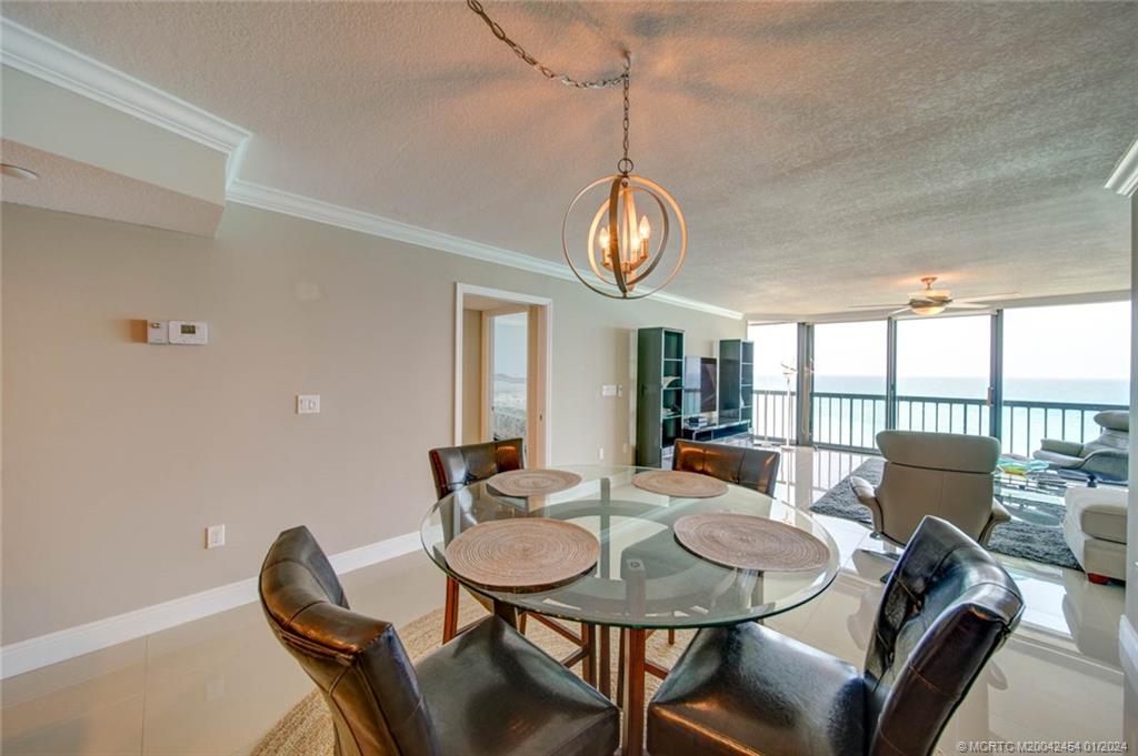 8800 South Ocean Drive, Unit 905 Jensen Beach, FL 34957 - Photo 13 of 67 a view of a dining room with furniture wooden floor and chandelier