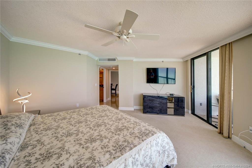 8800 South Ocean Drive, Unit 905 Jensen Beach, FL 34957 - Photo 26 of 67 a bedroom with a large bed and a flat screen tv
