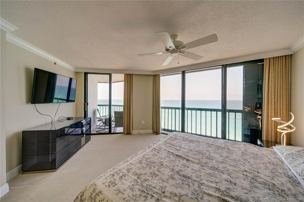 8800 South Ocean Drive, Unit 905 Jensen Beach, FL 34957 - Photo 27 of 67 a spacious bedroom with a large bed and a flat screen tv