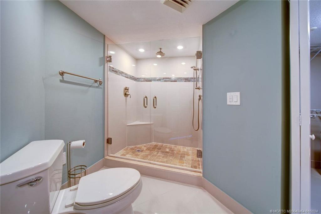 8800 South Ocean Drive, Unit 905 Jensen Beach, FL 34957 - Photo 29 of 67 a bathroom with a granite countertop sink toilet and shower