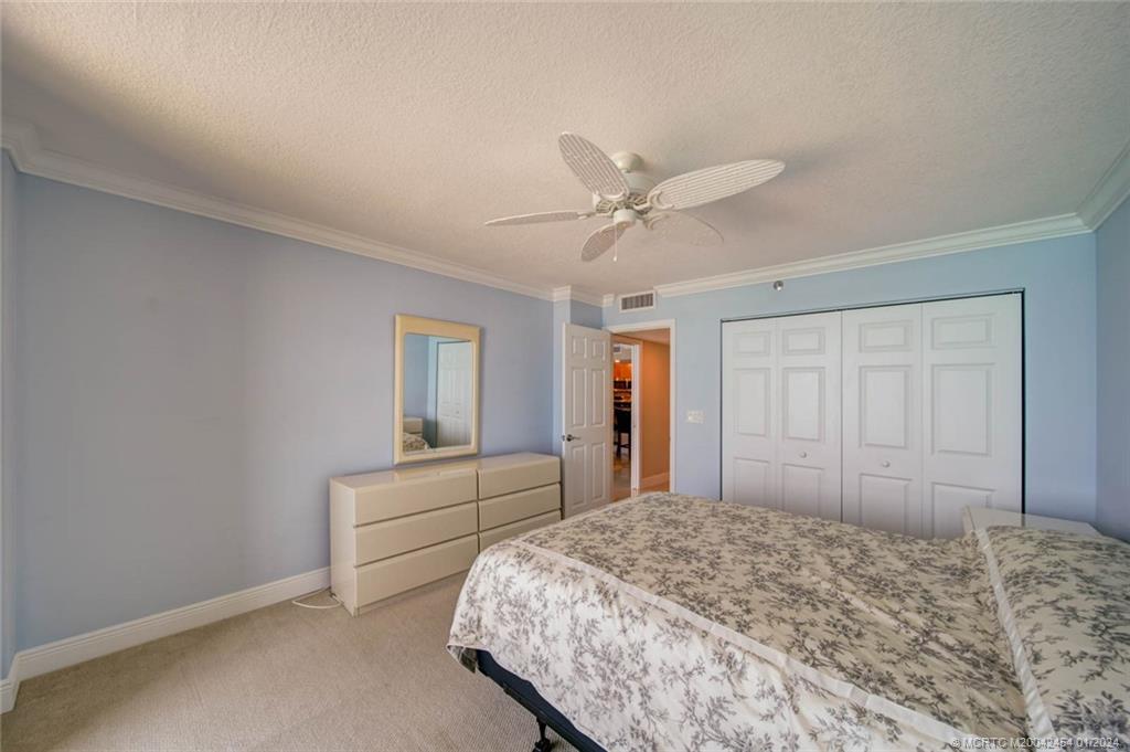 8800 South Ocean Drive, Unit 905 Jensen Beach, FL 34957 - Photo 33 of 67 a bedroom with a large bed and a chandelier