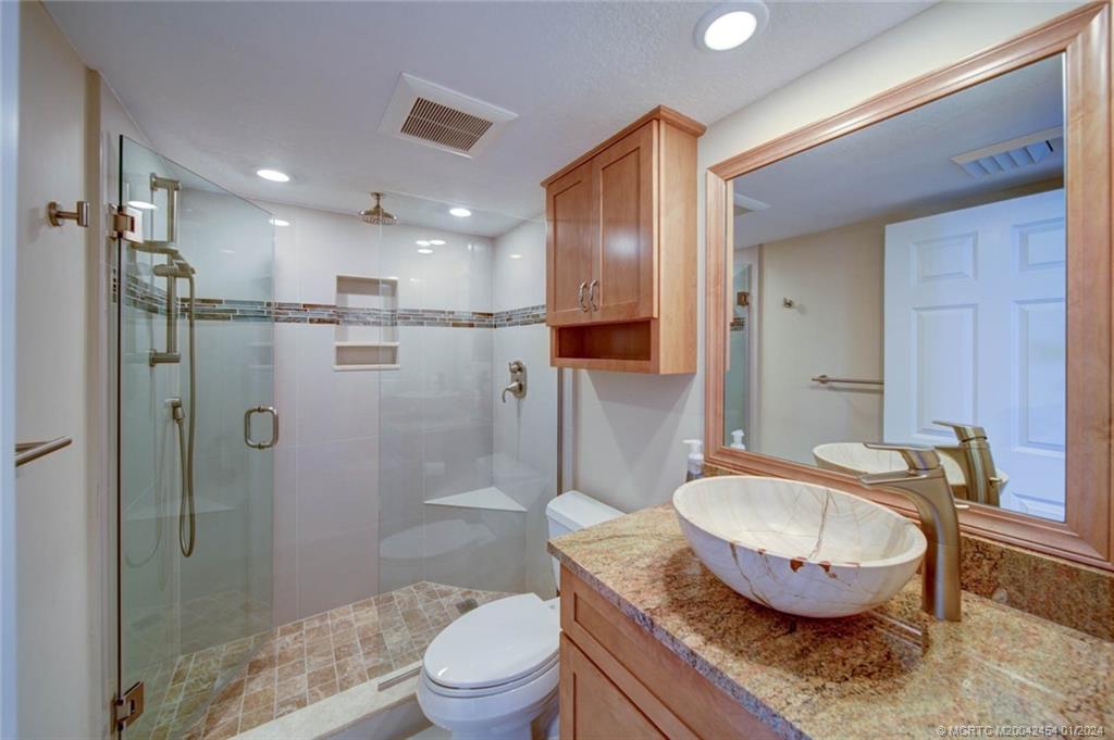 8800 South Ocean Drive, Unit 905 Jensen Beach, FL 34957 - Photo 34 of 67 a bathroom with a granite countertop sink a toilet and shower
