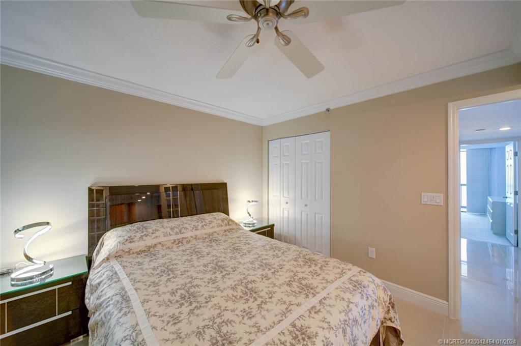 8800 South Ocean Drive, Unit 905 Jensen Beach, FL 34957 - Photo 35 of 67 a bedroom with a bed and a ceiling fan