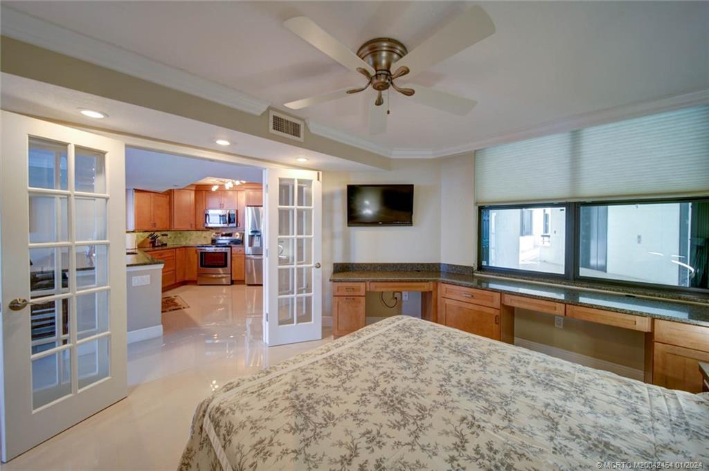 8800 South Ocean Drive, Unit 905 Jensen Beach, FL 34957 - Photo 37 of 67 a large kitchen with kitchen island a large counter top space appliances and a ceiling fan