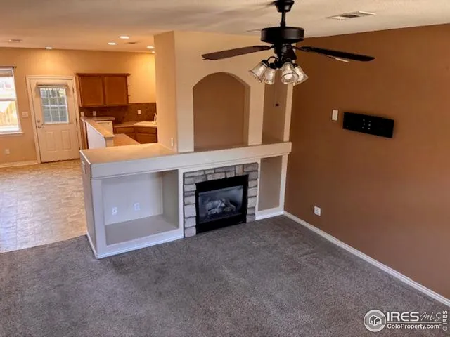 a view of a livingroom with a fireplace and window