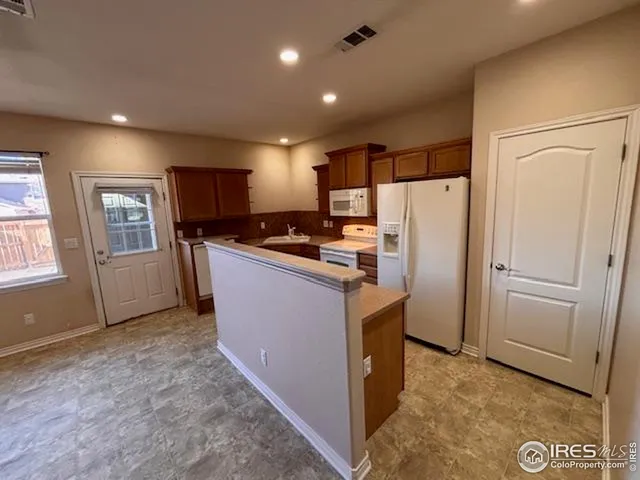 a kitchen with stainless steel appliances a refrigerator and a stove top oven