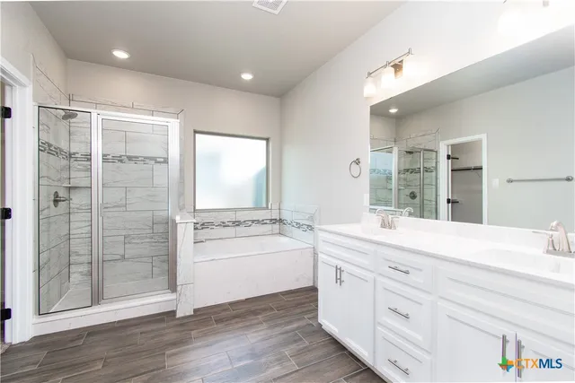 a spacious bathroom with a shower a sink and a large mirror