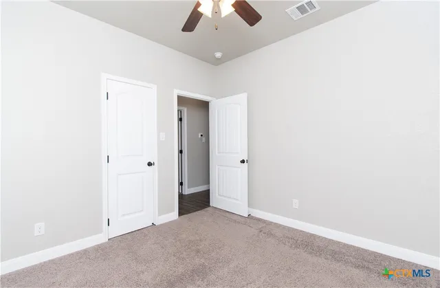 an empty room with chandelier fan