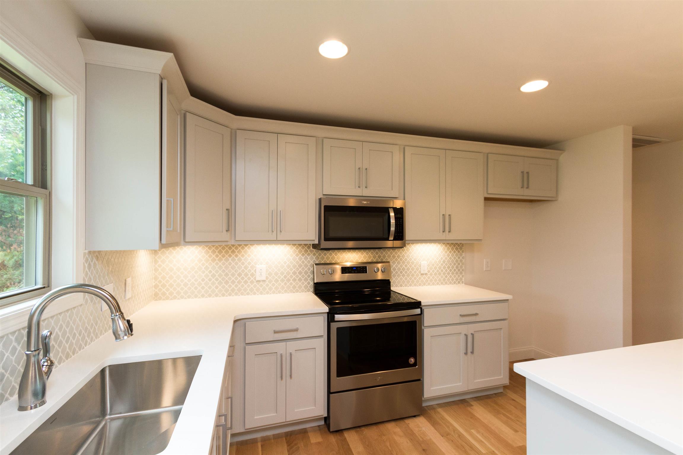 4121 Airport Road Springfield, TN 37172 - Photo 8 of 30 a kitchen with stainless steel appliances a stove top oven a sink a refrigerator and white cabinets with wooden floor