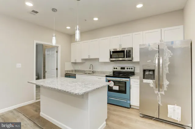 a kitchen with a refrigerator stove and sink