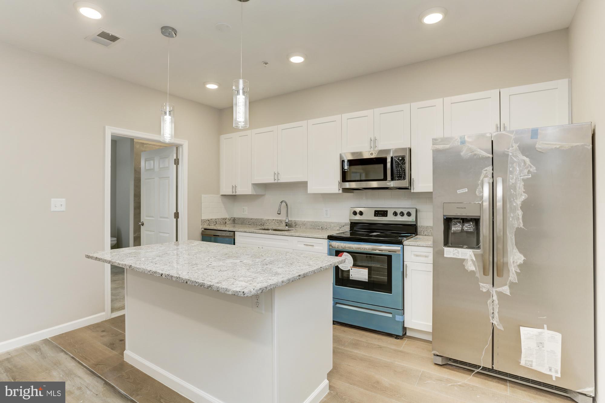 1923 Ashland Avenue, Unit 303 Baltimore, MD 21205 - Photo 5 of 13 a kitchen with a refrigerator stove and sink