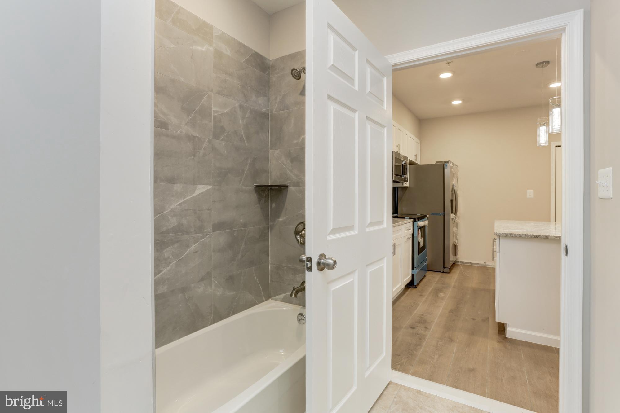 1923 Ashland Avenue, Unit 303 Baltimore, MD 21205 - Photo 10 of 13 a bathroom with a bathtub and a shower