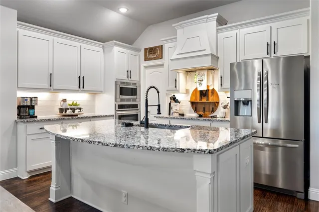 a kitchen with stainless steel appliances granite countertop a refrigerator a stove a sink and a granite counter tops