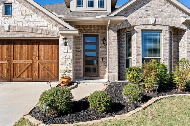 a front view of a house with a garden