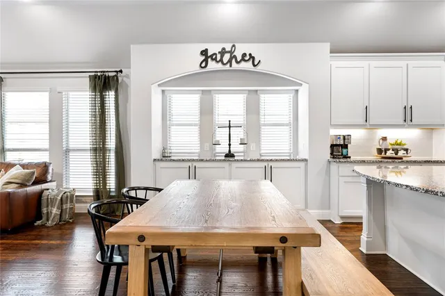 a large kitchen with a table chairs and wooden floor