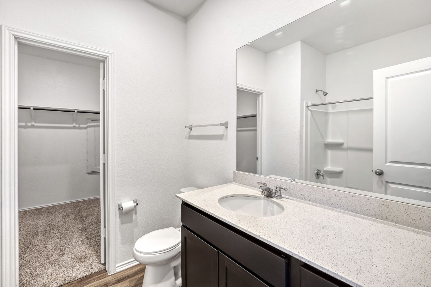 385 Geode Glen Maxwell, TX 78656 - Photo 12 of 16 Primary bathroom featuring vanity, a spacious closet, a shower, and dark wood-style floors