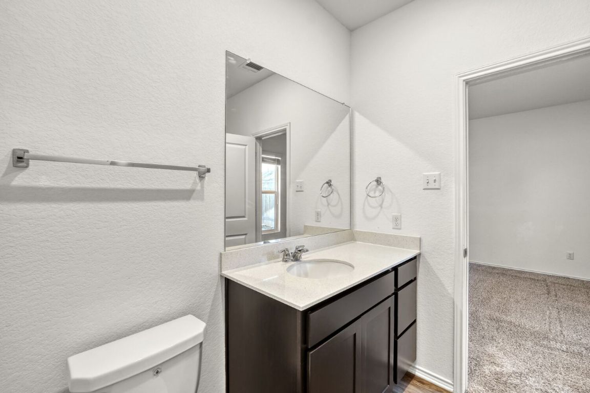 385 Geode Glen Maxwell, TX 78656 - Photo 13 of 16 Primary bathroom featuring a textured wall, and vanity