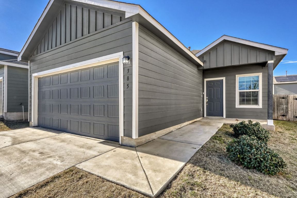 385 Geode Glen Maxwell, TX 78656 - Photo 2 of 16 View of front of house with board and batten siding, driveway, and a garage