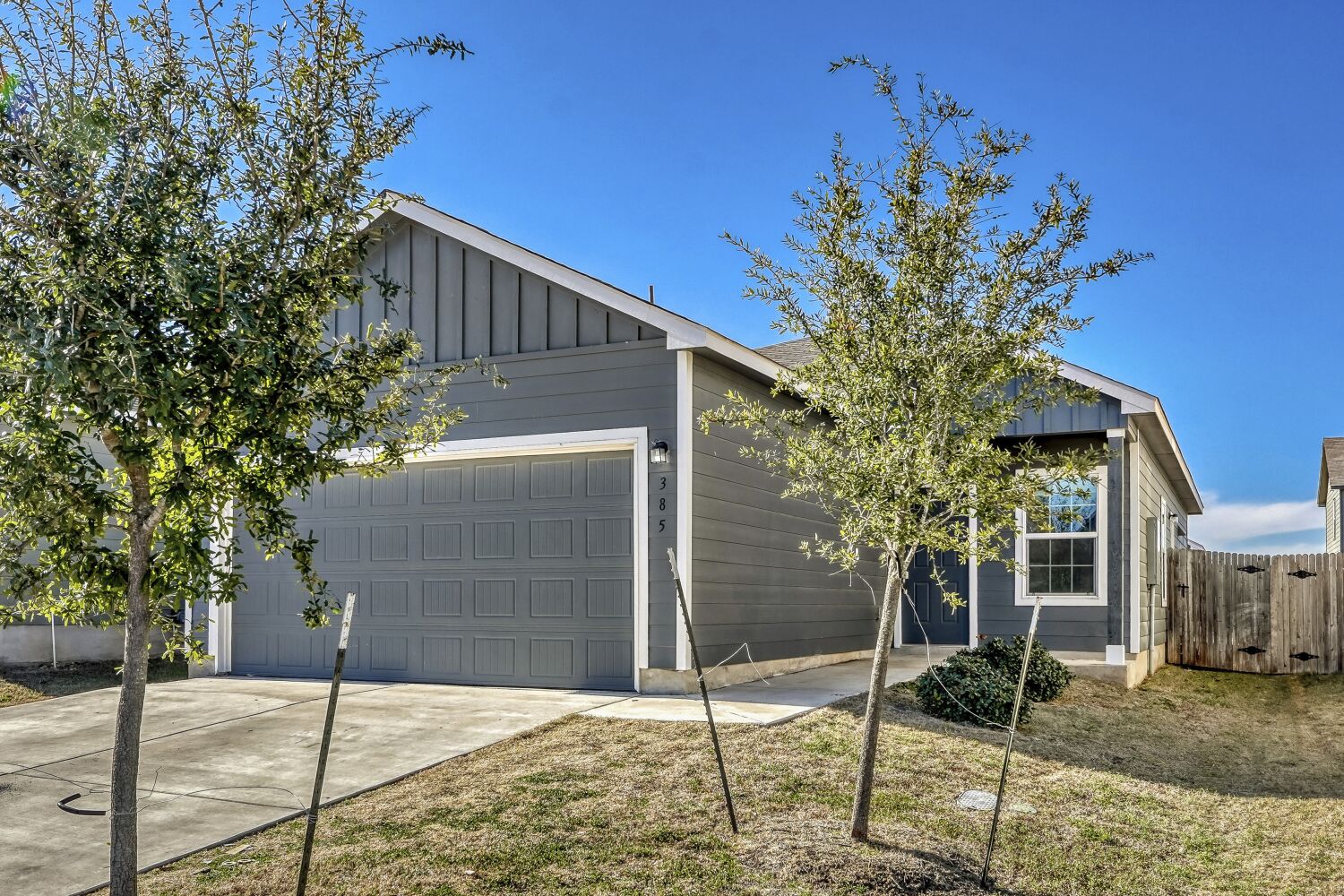 385 Geode Glen Maxwell, TX 78656 - Photo 3 of 16 View of front of house featuring board and batten siding, driveway, and a garage
