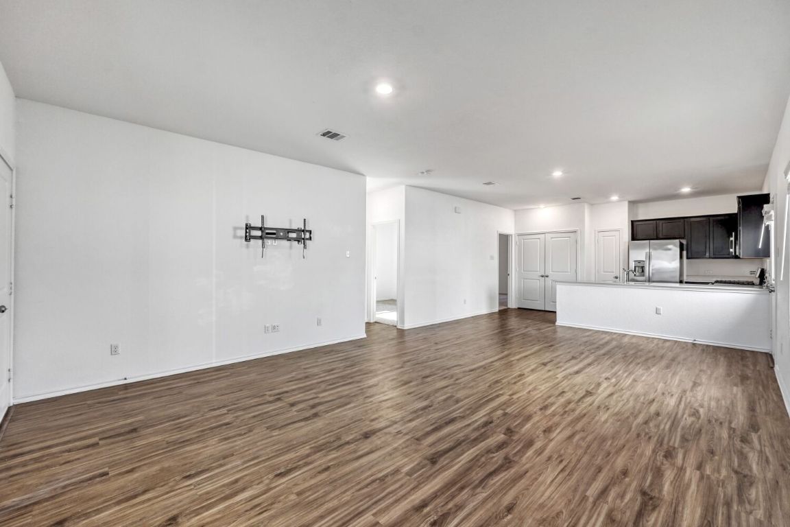 385 Geode Glen Maxwell, TX 78656 - Photo 5 of 16 Unfurnished living and dining room with recessed lighting and dark wood-type flooring