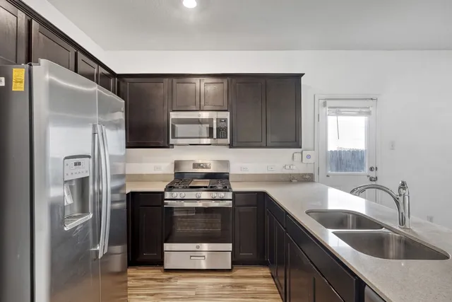 a kitchen with a refrigerator sink and cabinets