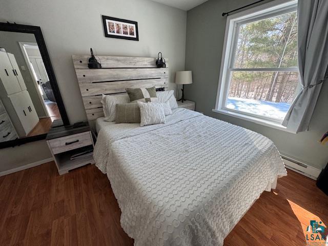 15081 Old Hart Lake Road Goodland, MN 55742 - Photo 10 of 18 Bedroom featuring dark wood-style flooring and baseboard heating