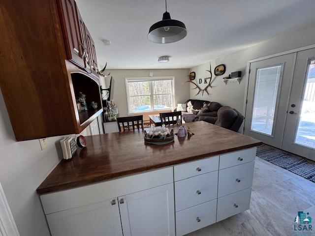15081 Old Hart Lake Road Goodland, MN 55742 - Photo 18 of 18 Kitchen with french doors, wood counters, decorative light fixtures, white cabinetry, and open floor plan