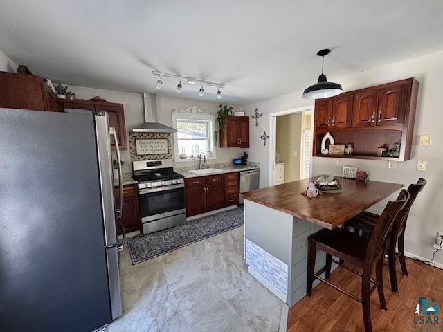 15081 Old Hart Lake Road Goodland, MN 55742 - Photo 7 of 18 Kitchen with stainless steel appliances, hanging light fixtures, a peninsula, wooden counters, and open shelves
