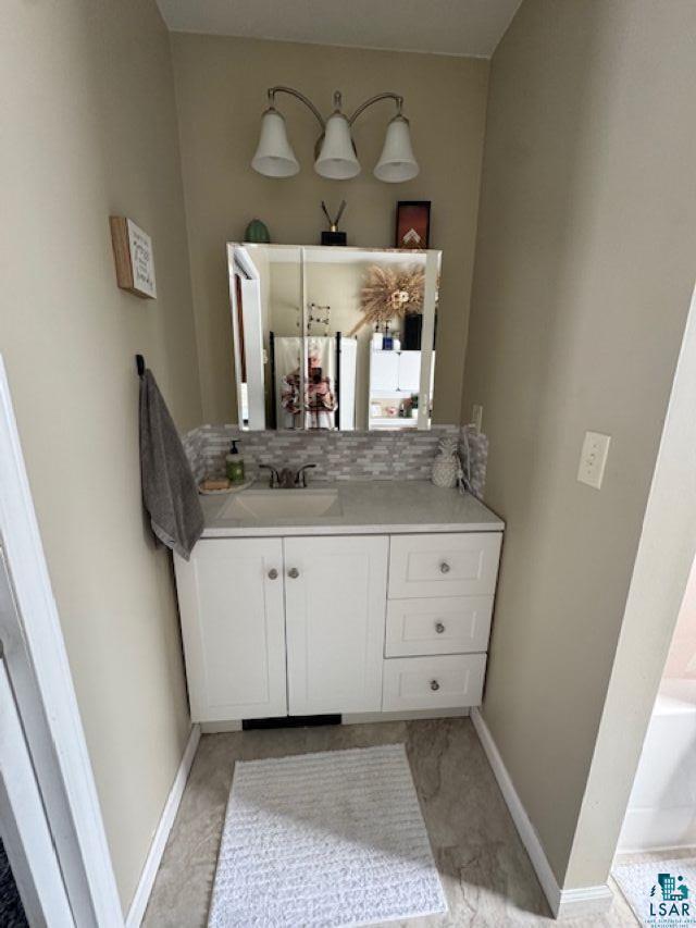 15081 Old Hart Lake Road Goodland, MN 55742 - Photo 8 of 18 Bathroom featuring vanity and decorative backsplash