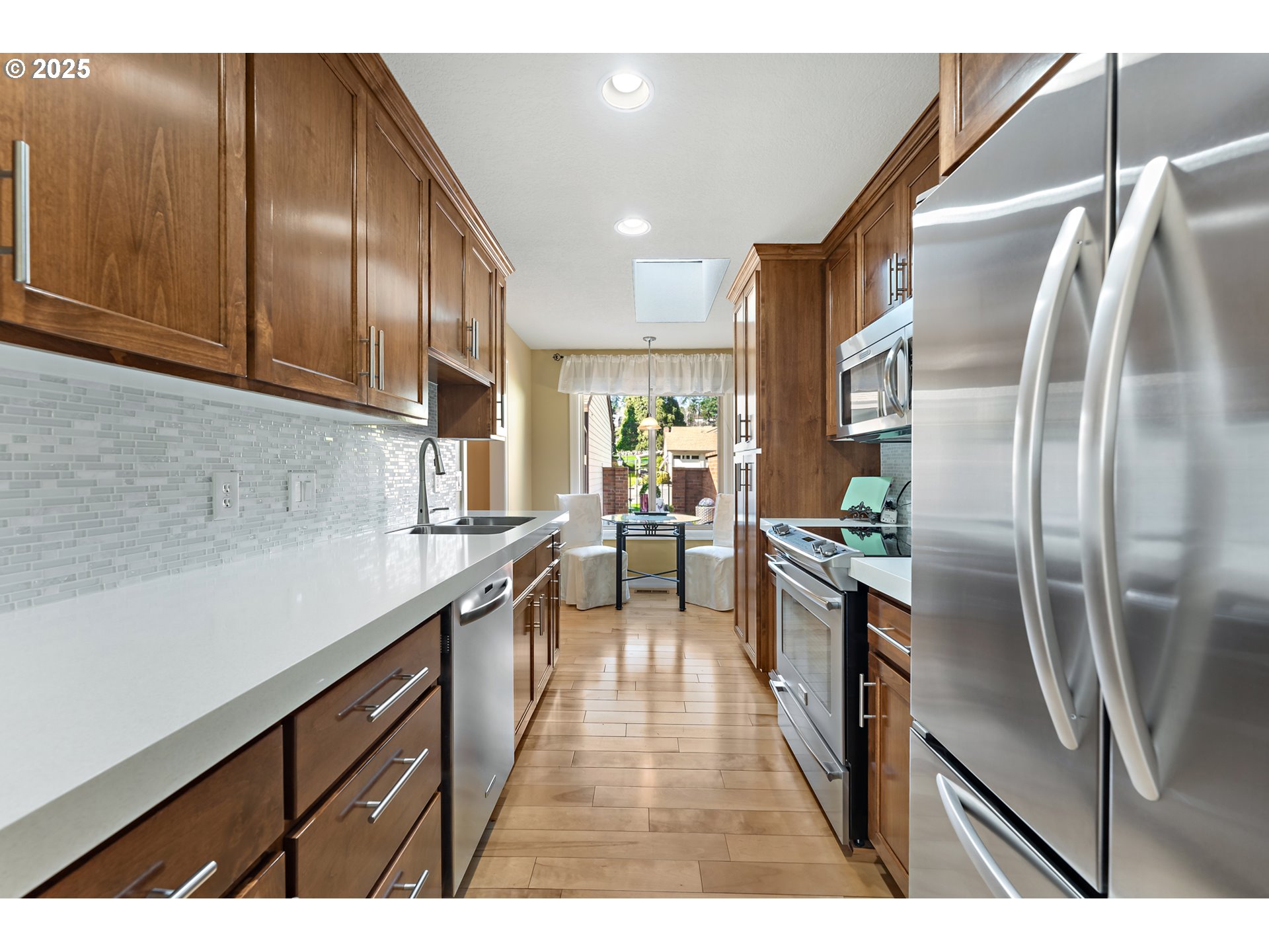 10350 Southwest Greenleaf Terrace Portland, OR 97224 - Photo 6 of 32 a kitchen with stainless steel appliances granite countertop a refrigerator a sink a stove and a wooden floors
