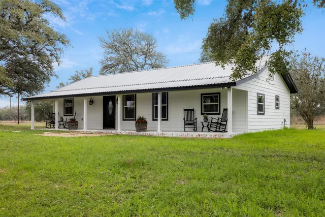 a view of a house with a yard patio and fire pit