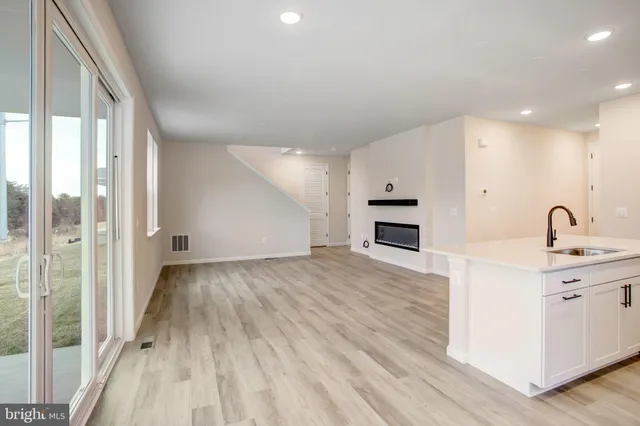a view of a kitchen with a sink dishwasher and a fireplace