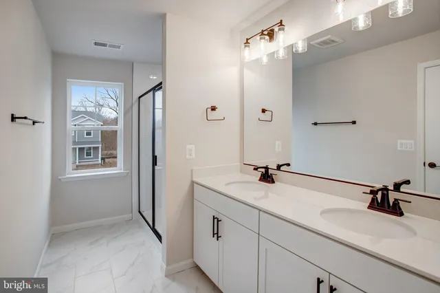 a bathroom with a sink and mirror with shower