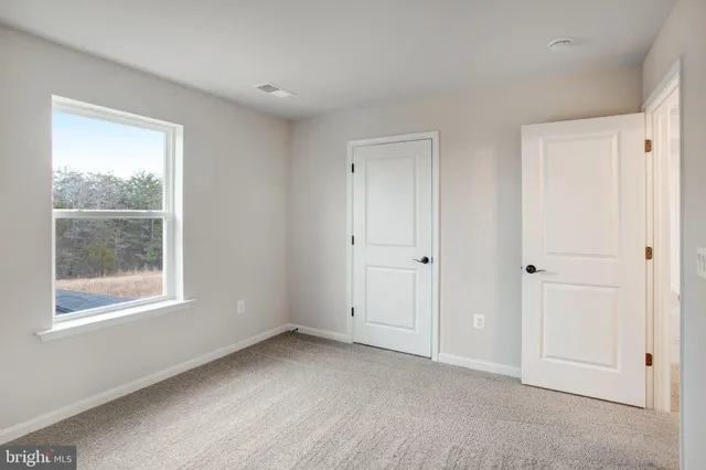 an empty room with windows and closet