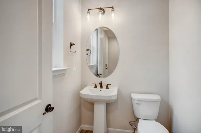 a bathroom with a toilet sink and mirror