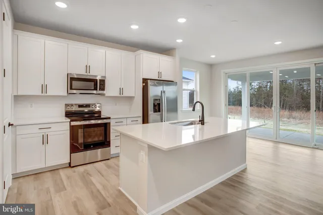 a large kitchen with stainless steel appliances granite countertop a stove a sink and a refrigerator