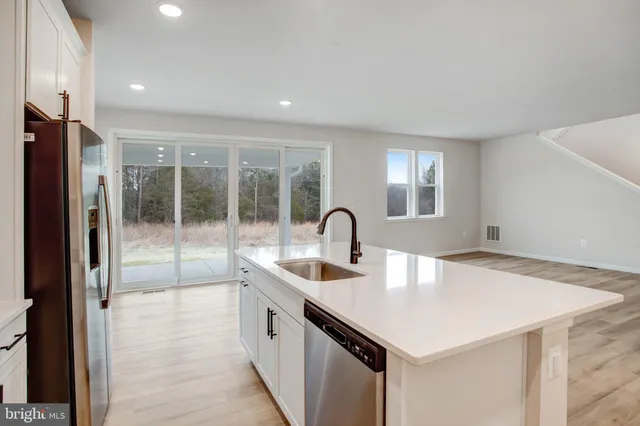 a kitchen with a sink a counter top space and stainless steel appliances