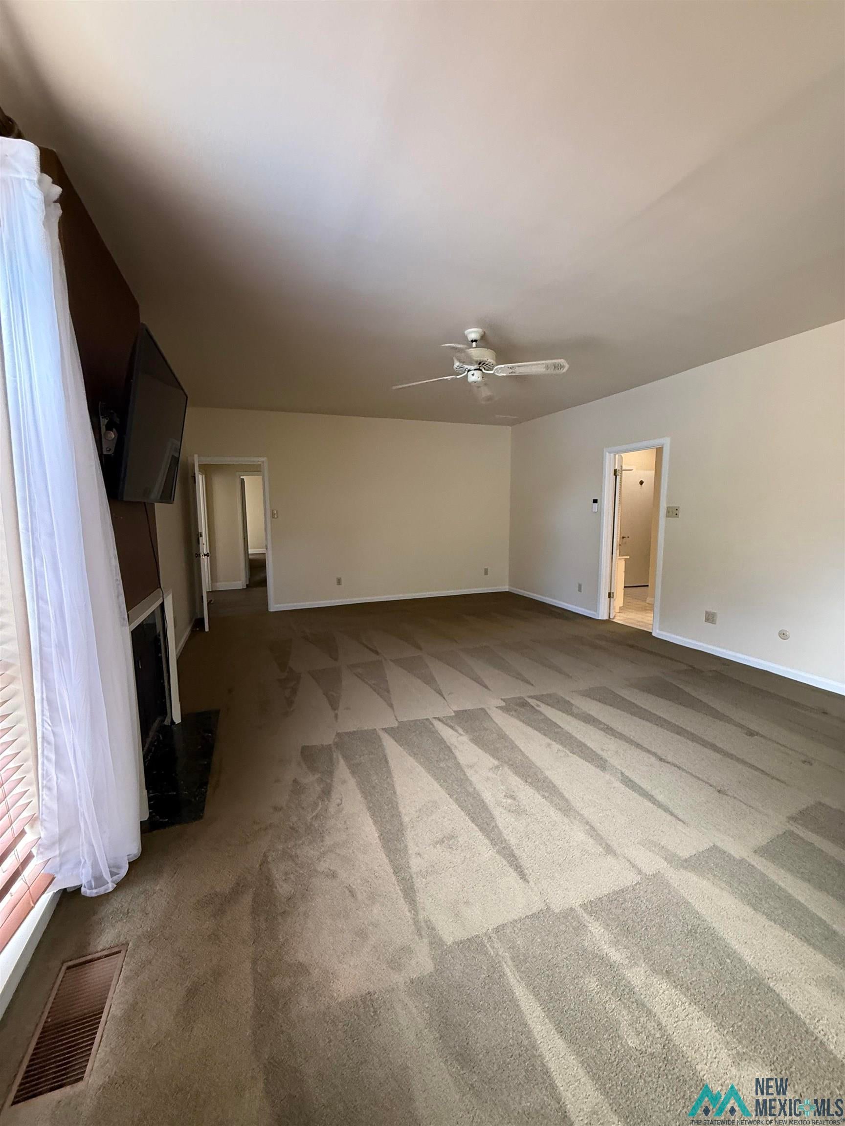 1111 West Country Road Roswell, NM 88201 - Photo 29 of 41 Spacious living area featuring neutral carpeting and light-colored walls