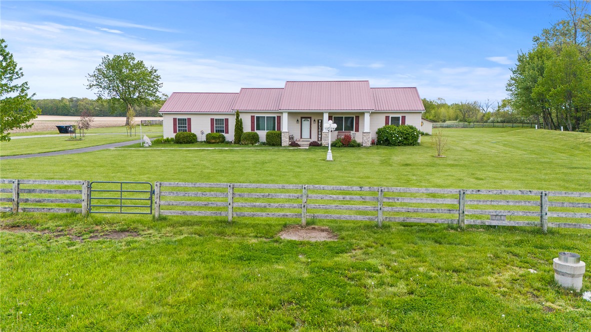4222 Ramsey Road Springfield, OH 45502 - Photo 10 of 79 This charming home sits on a spacious green lawn with a classic fence, inviting serene outdoor living.