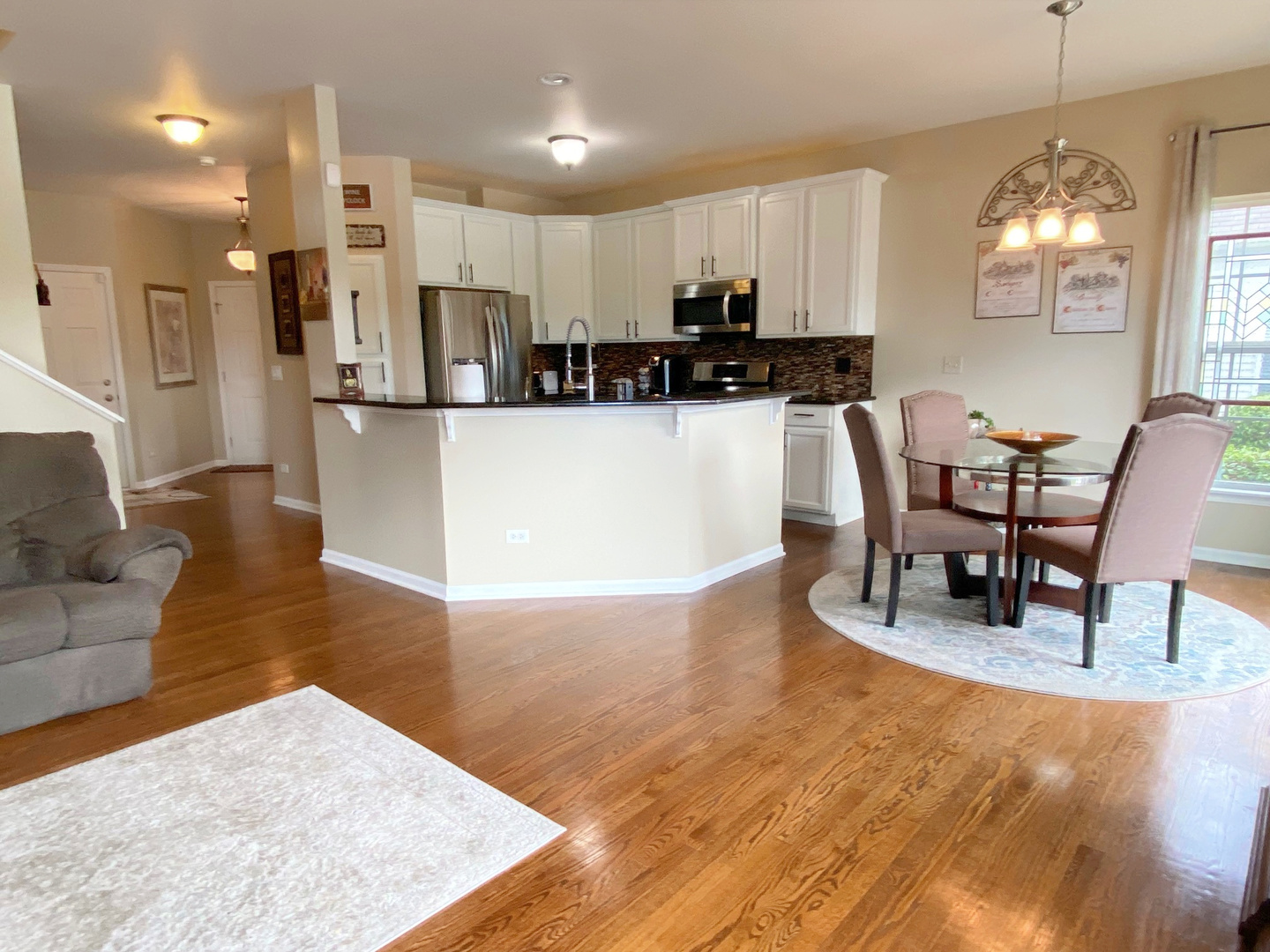 1197 Freedom Road Elburn, IL 60119 - Photo 9 of 31 a living room with stainless steel appliances kitchen island granite countertop a table chairs and a microwave
